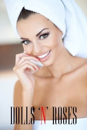 Beautiful tanned woman in a beauty portrait with her head and body wrapped in clean fresh white towels smiling as she waits in a spa or resort for a pampering rejuvenating treatment